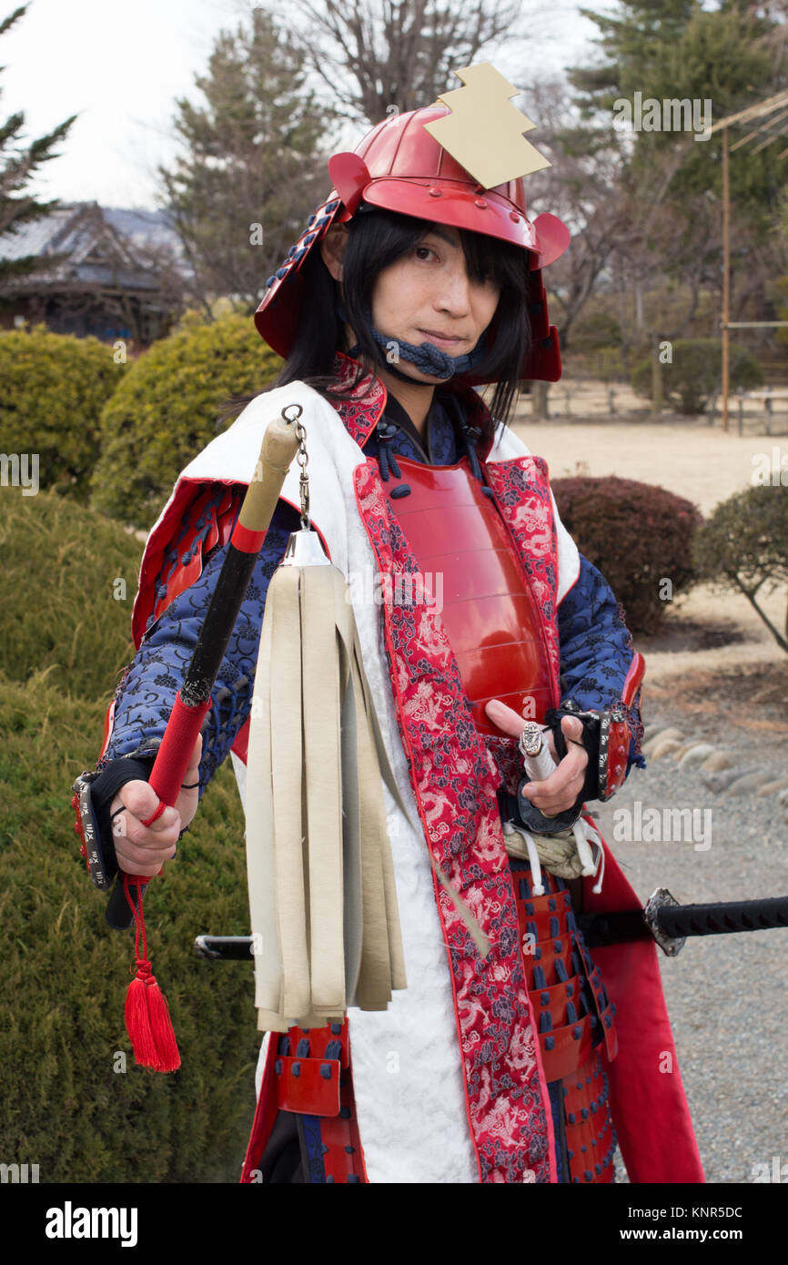 Matsumoto Castle is one of Japan's premier historic castles. A guide is pictured wearing traditional dress at the entrance. Stock Photo