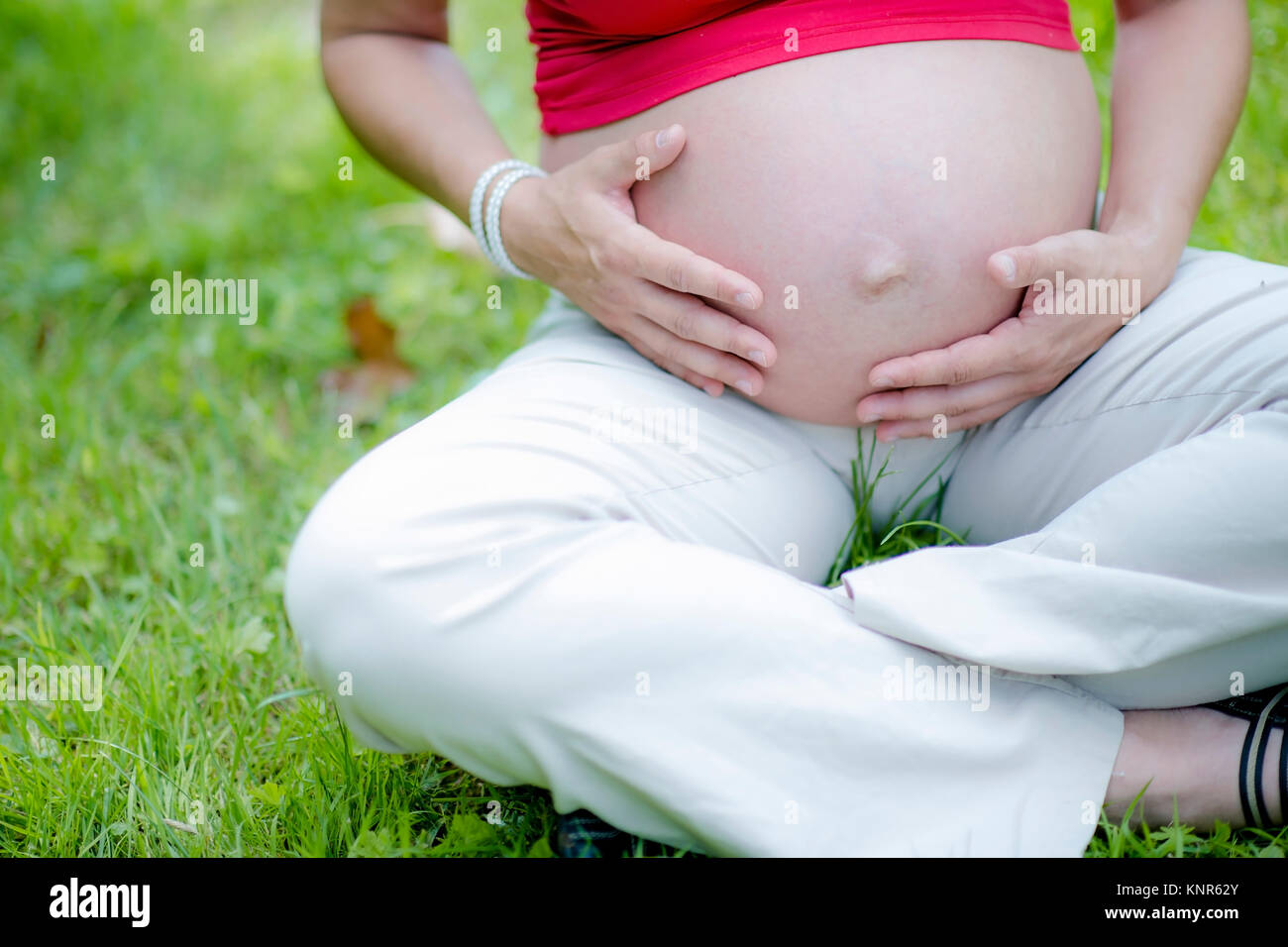 Schwangere Frau greift sich an den Babybauch - pregnant woman Stock Photo