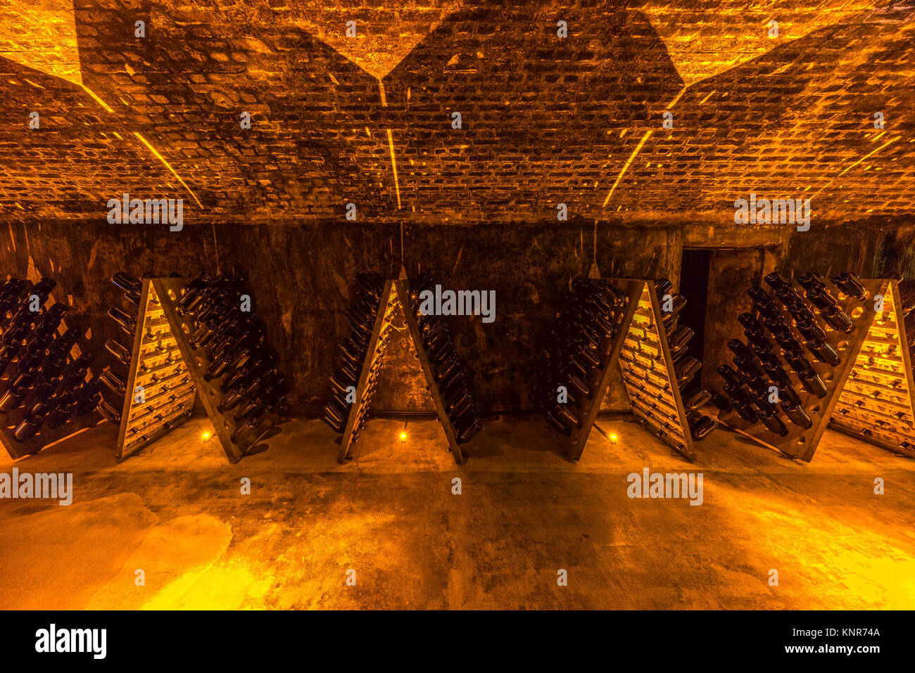 Sparkling wine bottles aging in old cellar, France Stock Photo