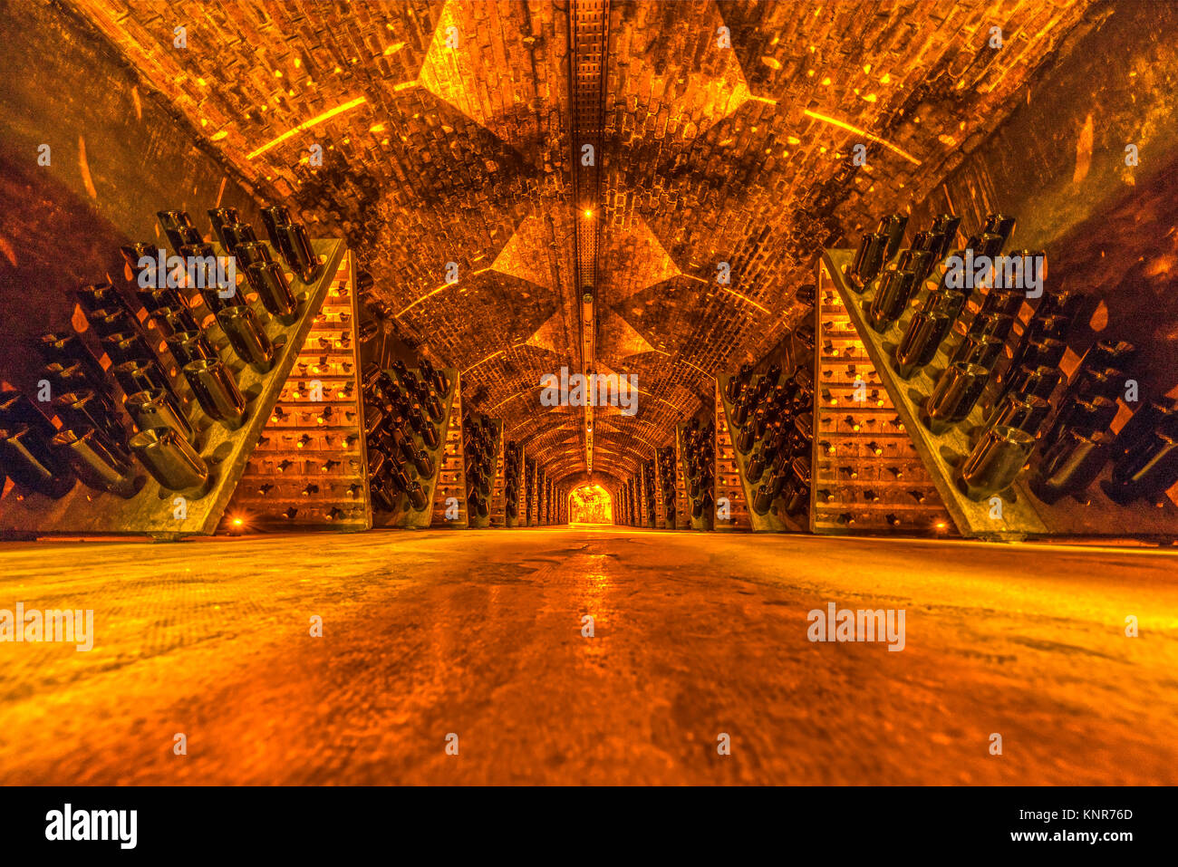Sparkling wine bottles aging in old cellar, France Stock Photo