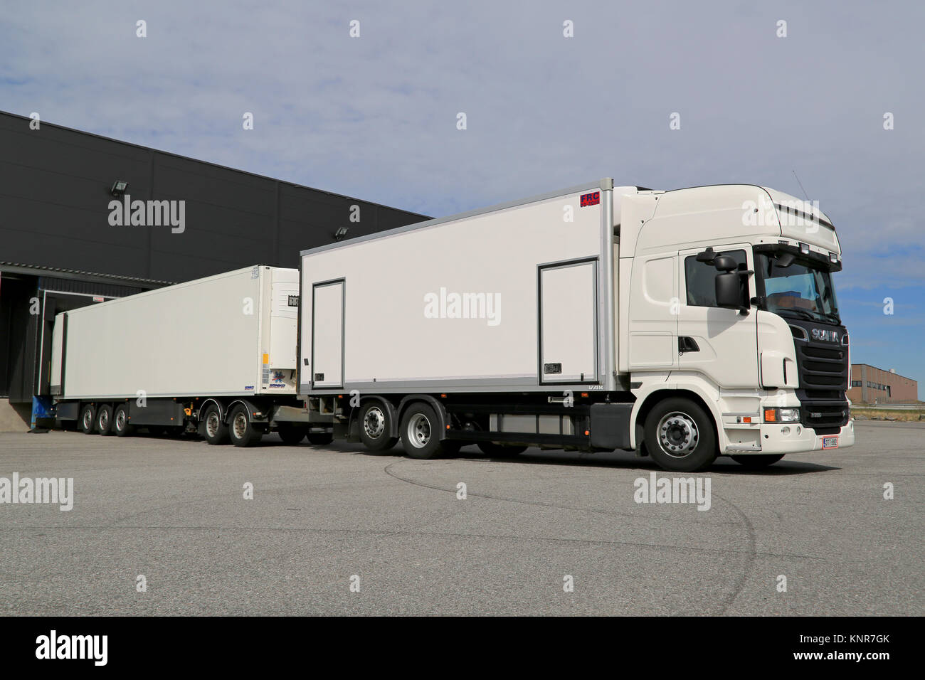 TURKU, FINLAND - APRIL 26, 2014: White Scania R560 truck unloading at a warehouse. According to Statistics Finland, the volume of goods transported by Stock Photo