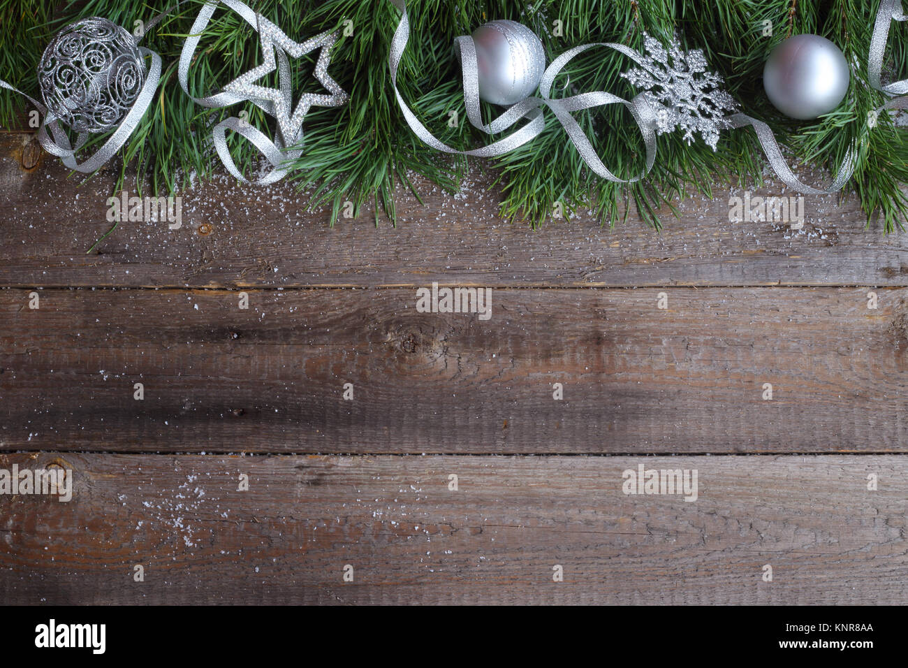 Christmas card on wooden background with snow fir tree and silver decor ...
