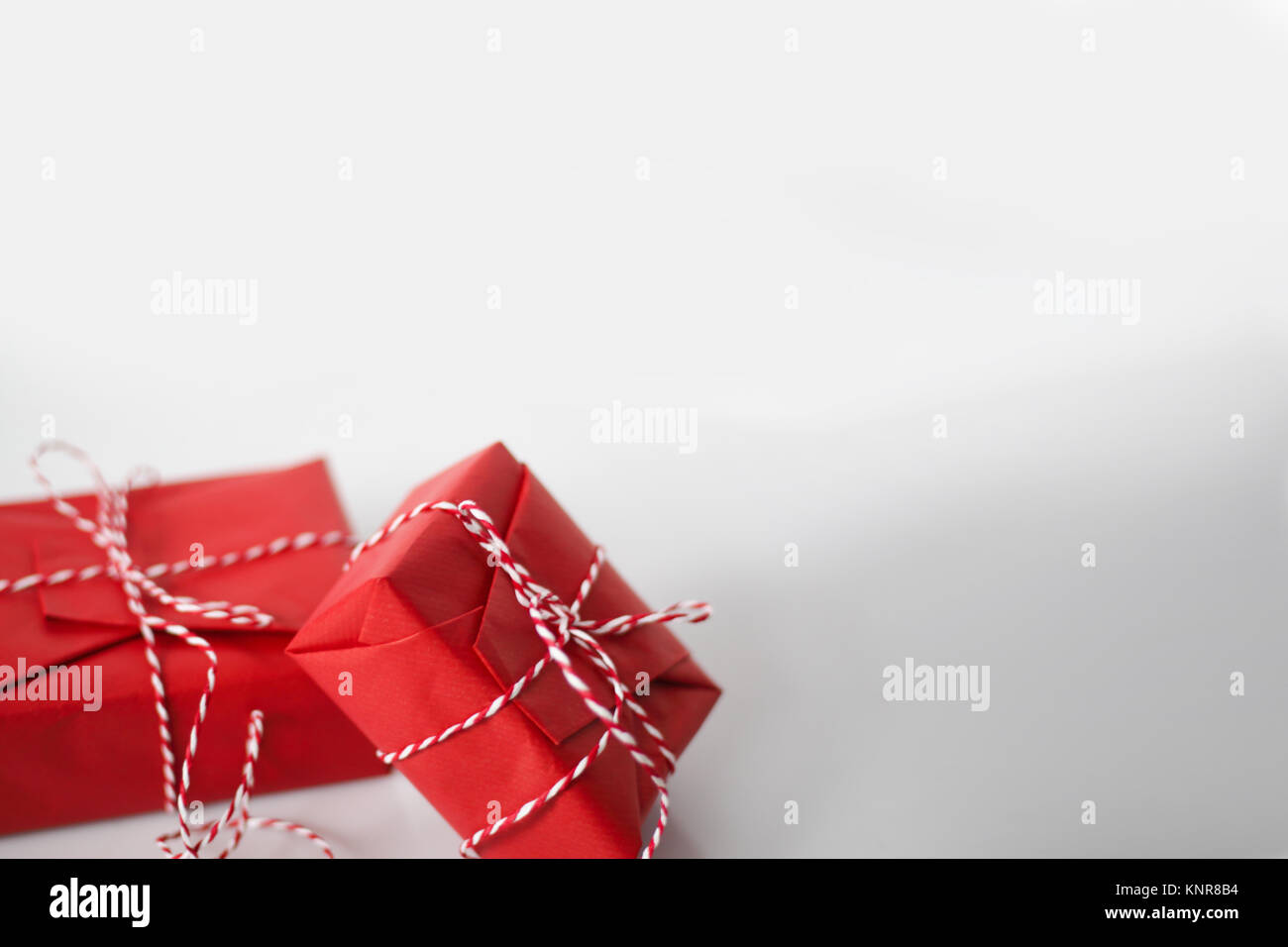 Christmas gift boxes wrapped in red paper and bow of dtriped rope on ...