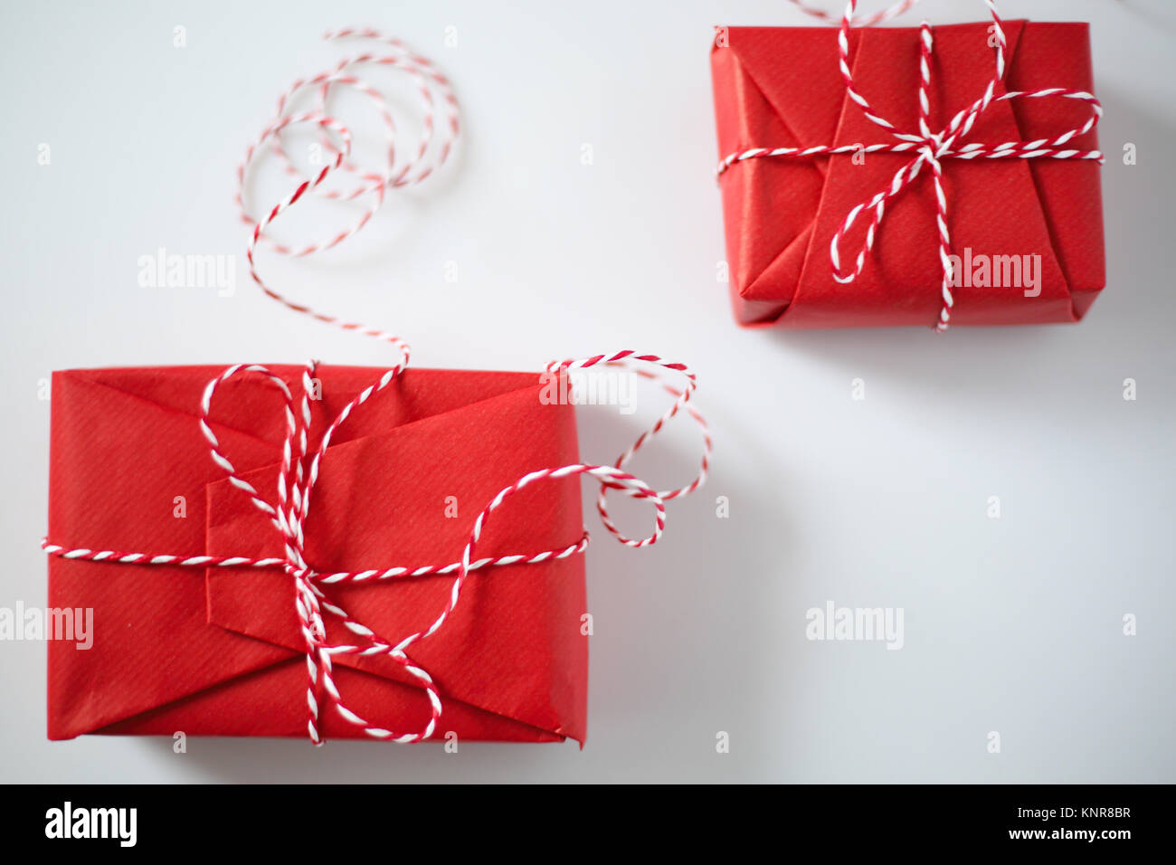 Christmas gift boxes wrapped in red paper and bow of dtriped rope on ...