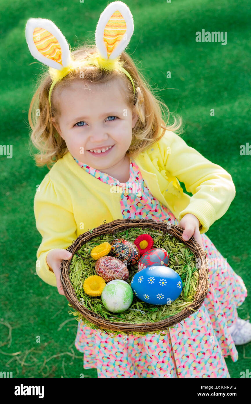 Maedchen mit Hasenohren haelt Osternest in der Hand - Easter girl with Easter nest Stock Photo