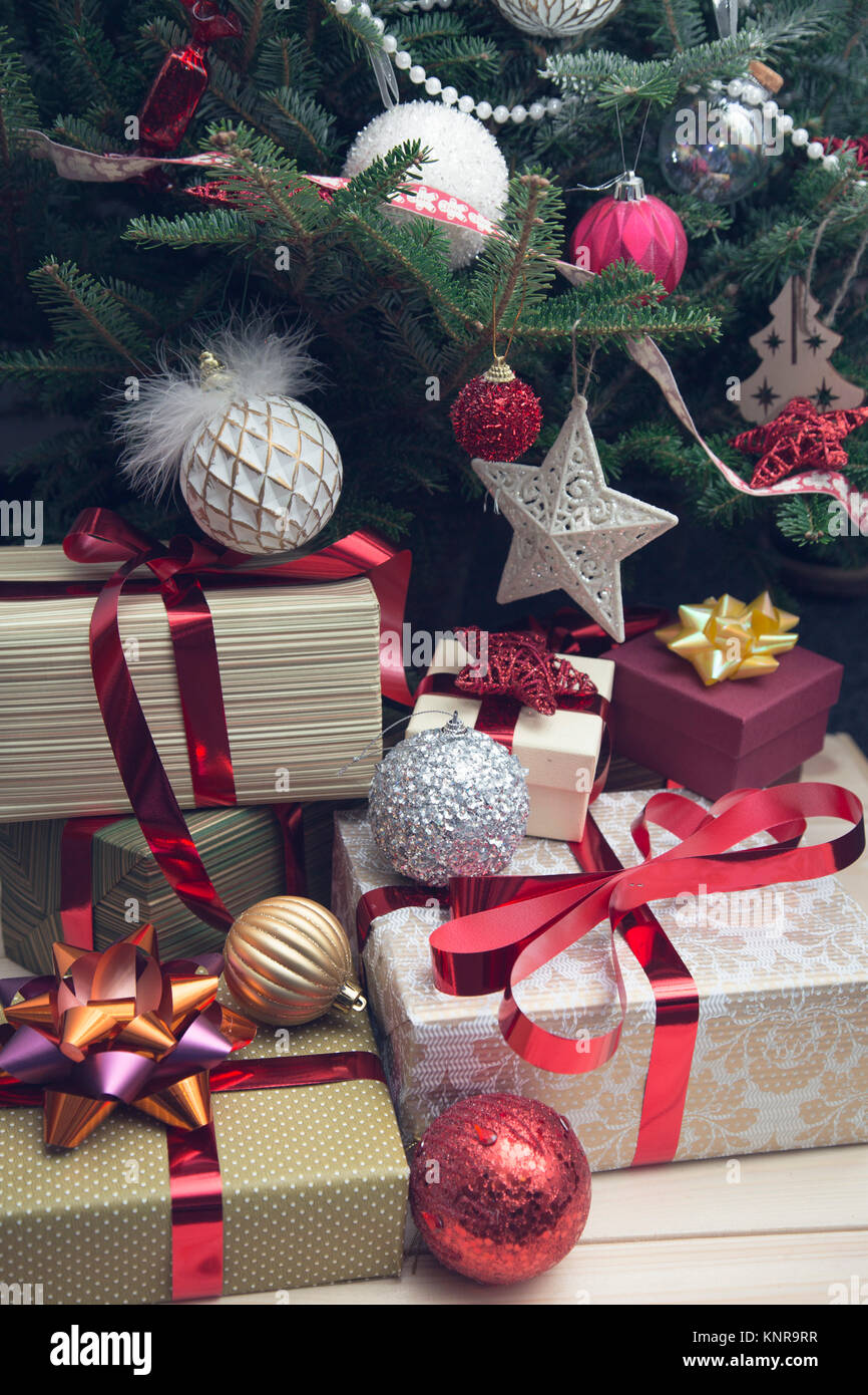 A pile of gift boxes patterns tied with red metallic ribbons under a ...
