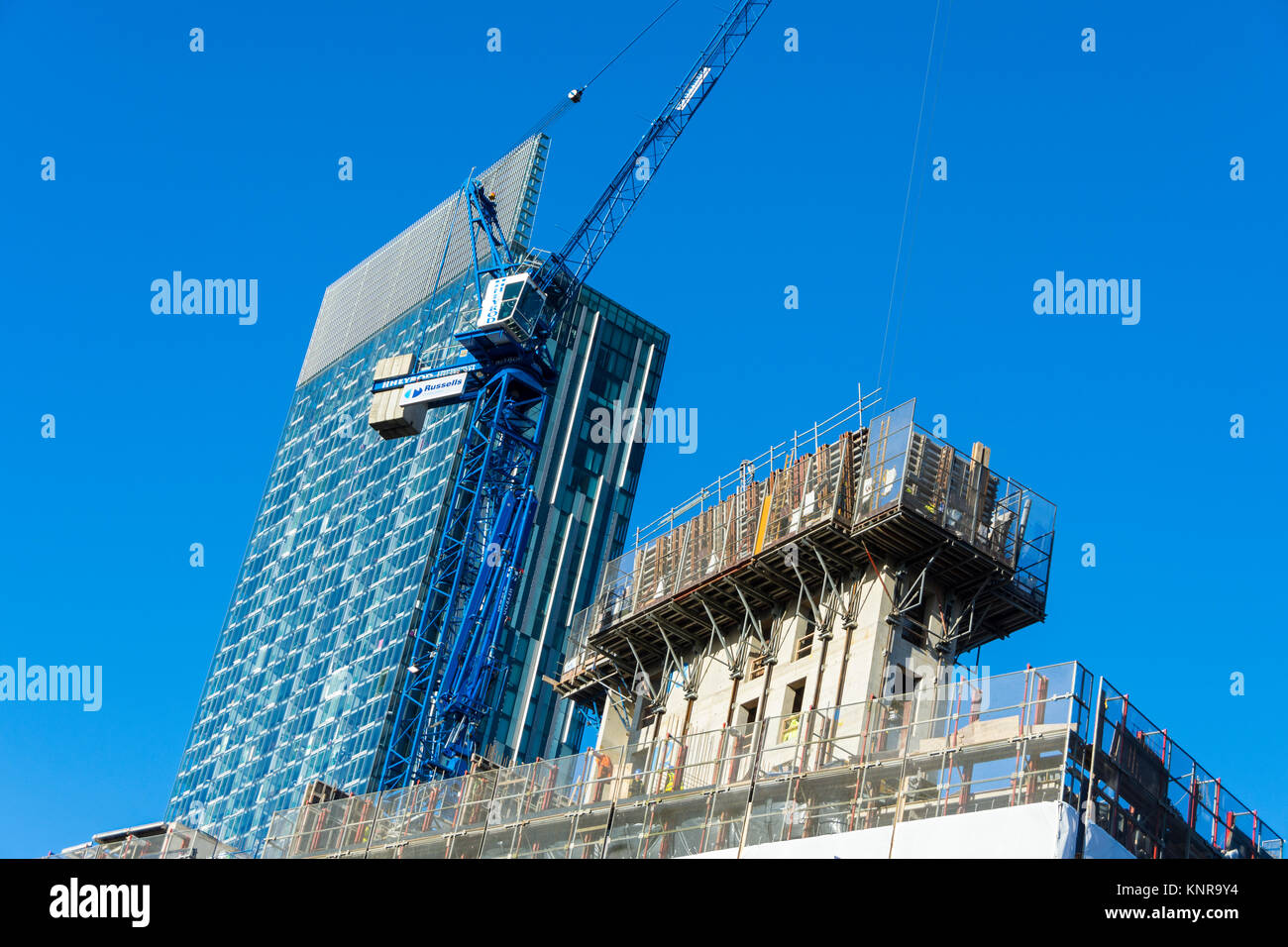 The Axis Tower apartment block development under construction with the Beetham Tower behind.  Whitworth Street West, Manchester, England, UK. Stock Photo