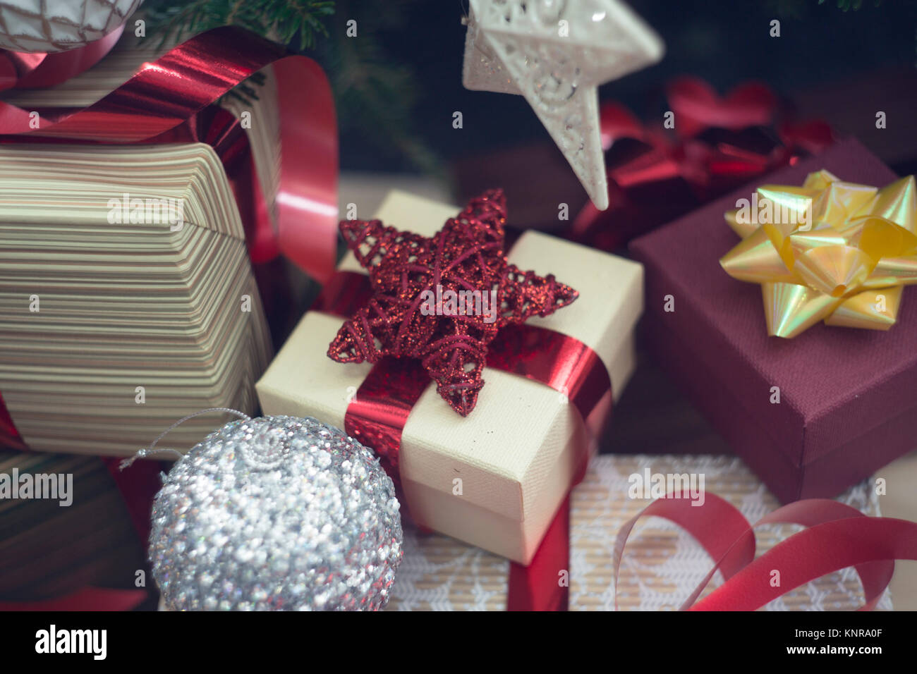 A pile of beautiful gift boxes tied with metallic red ribbon, a ...