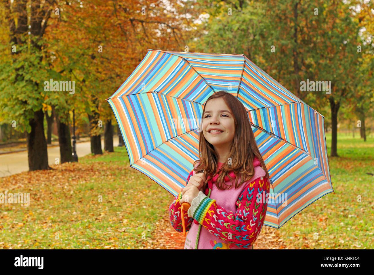 happy little girl with umbrella in park autumn season Stock Photo - Alamy