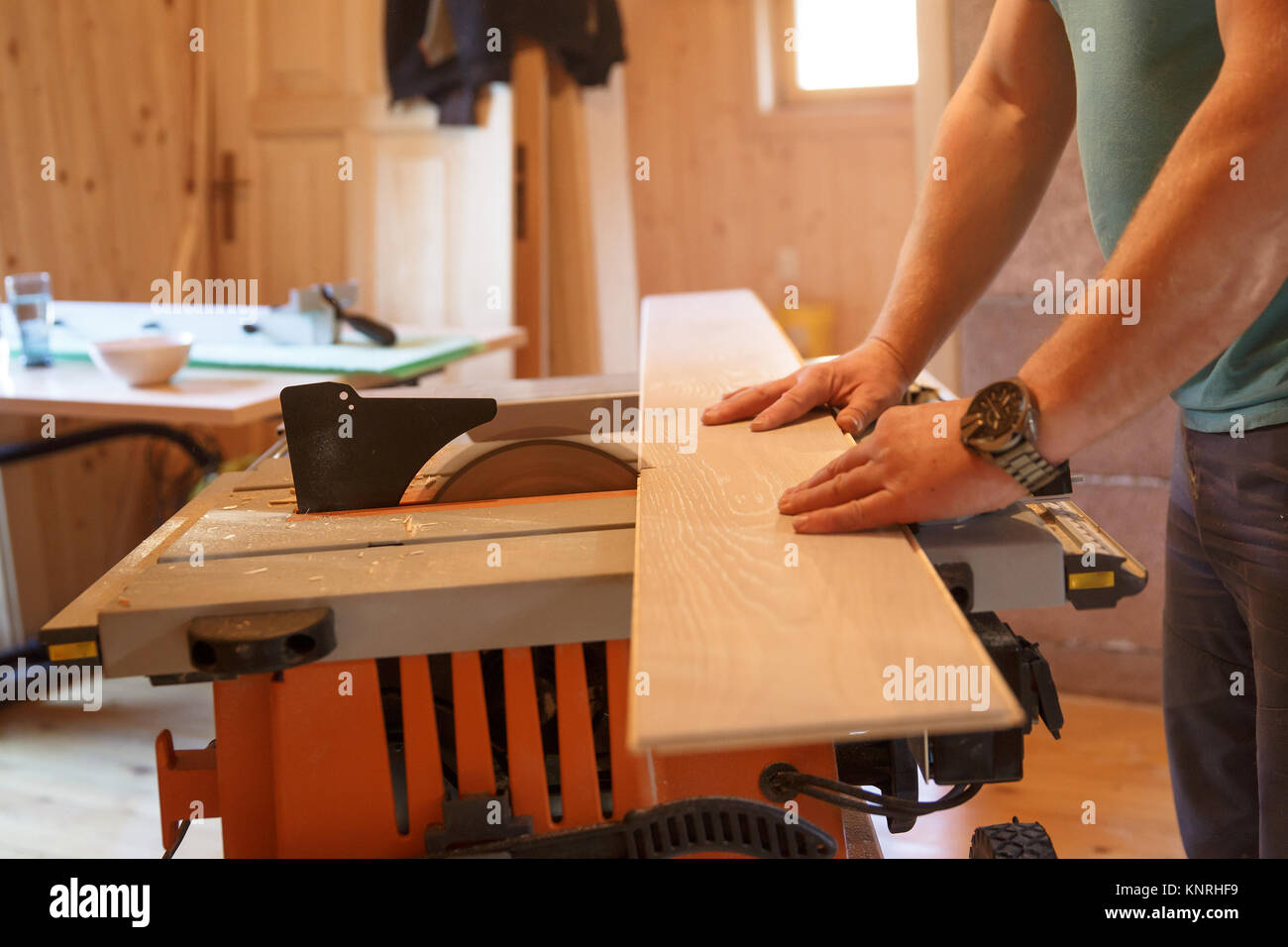 Worker using professional circular saw, cutting click oak parquet. DIY, professional work, home improvement and renovation, parquetry concept. Stock Photo