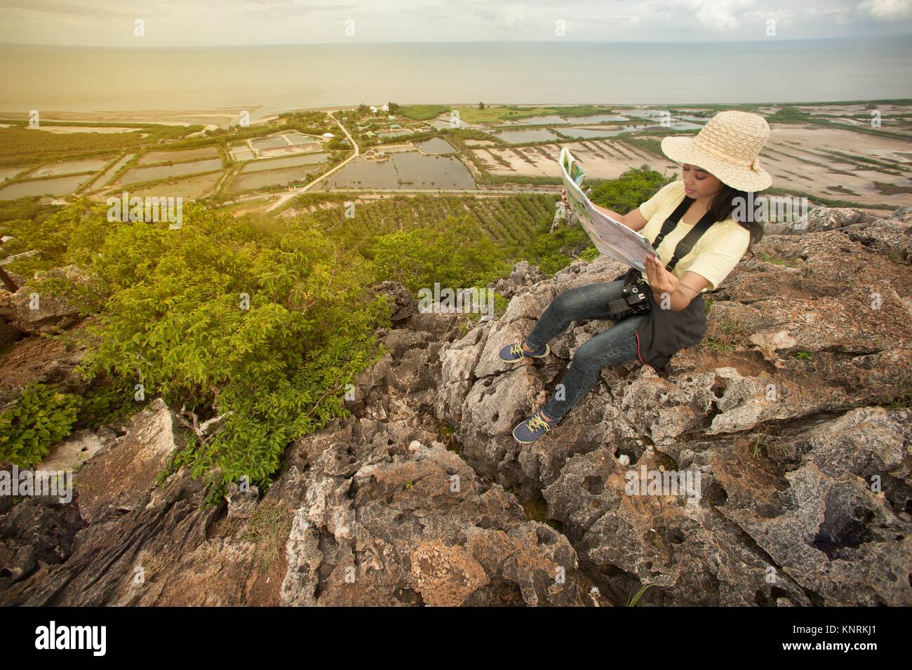 Pretty Asian woman hiking and climbing reading a map on top of ...