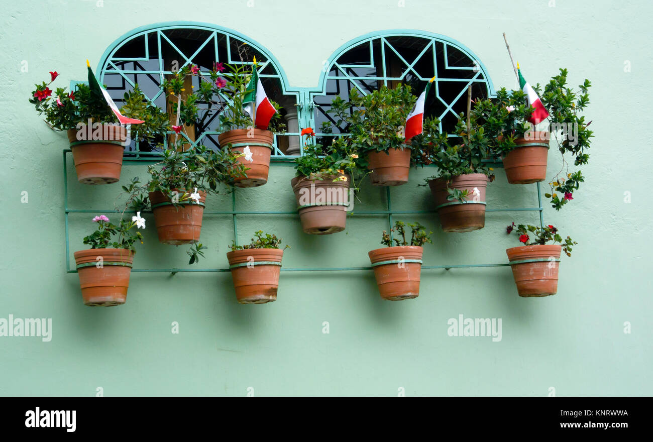 Mexican flags in flower pots outside windows in Ajijic to celebrate Mexican Independence day  (September 16) Stock Photo