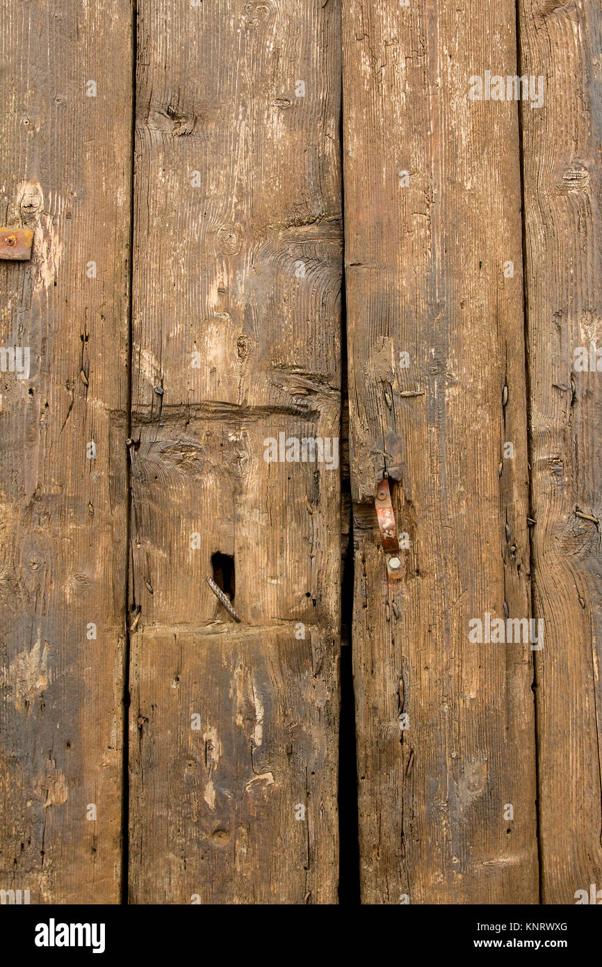 Close-up of old, textured, rustic, weathered, brown wooden door. Stock Photo