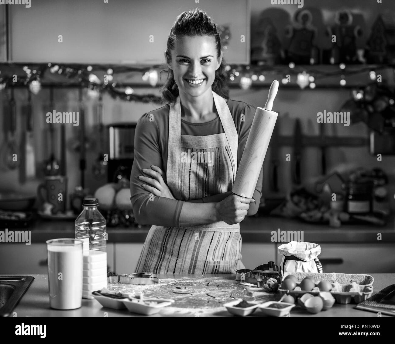 Portrait of smiling young housewife with rolling pin Stock Photo