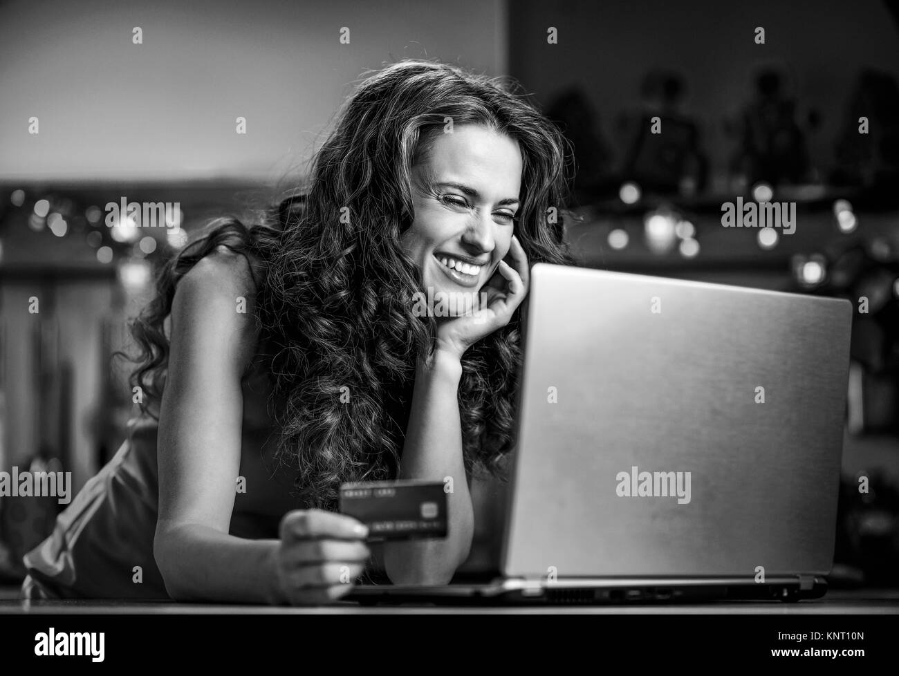 Christmas holidays are a time of gift-giving. Online shopping can make Christmas season less stressful and more enjoyable. Happy young woman holding c Stock Photo