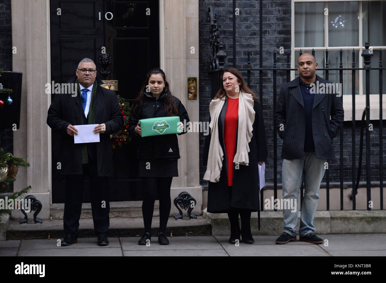 Victims or family of victims of the Grenfell Tower fire, Nicholas Burton (left), Sandra Ruiz (second right), Karim Mussilhy (right) and a girl who asked not be named (second left), hand in a petition to Downing Street, London, asking for an overhaul of the public inquiry. Stock Photo