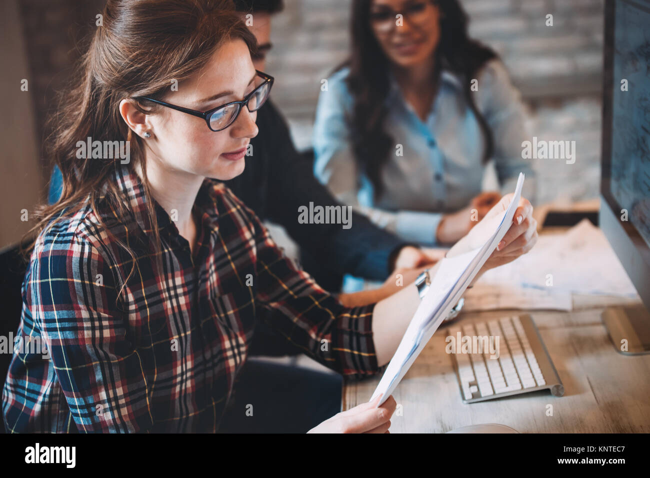 Happy female architect in office looking at blueprint Stock Photo - Alamy
