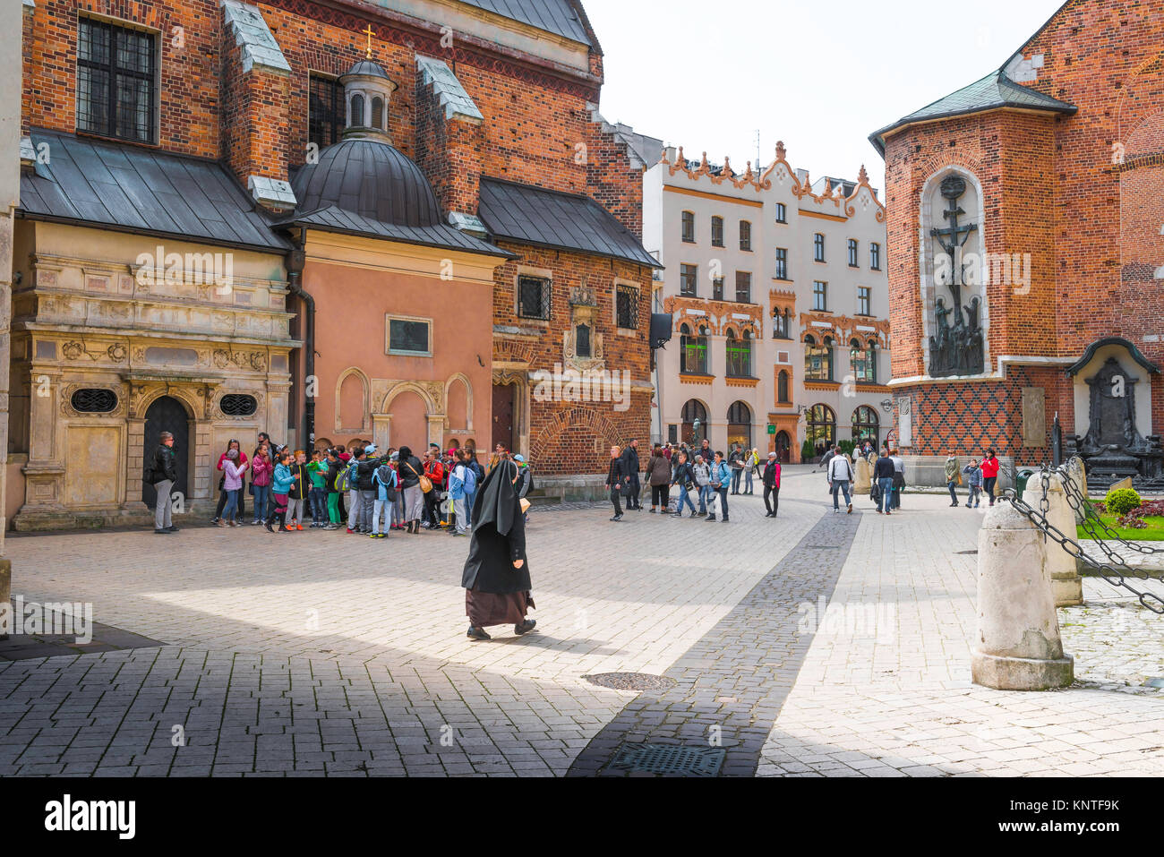 Medieval Krakow, a nun walks through St Mary's Square (Plac Mariacki) in the medieval center of Krakow, Poland. Stock Photo