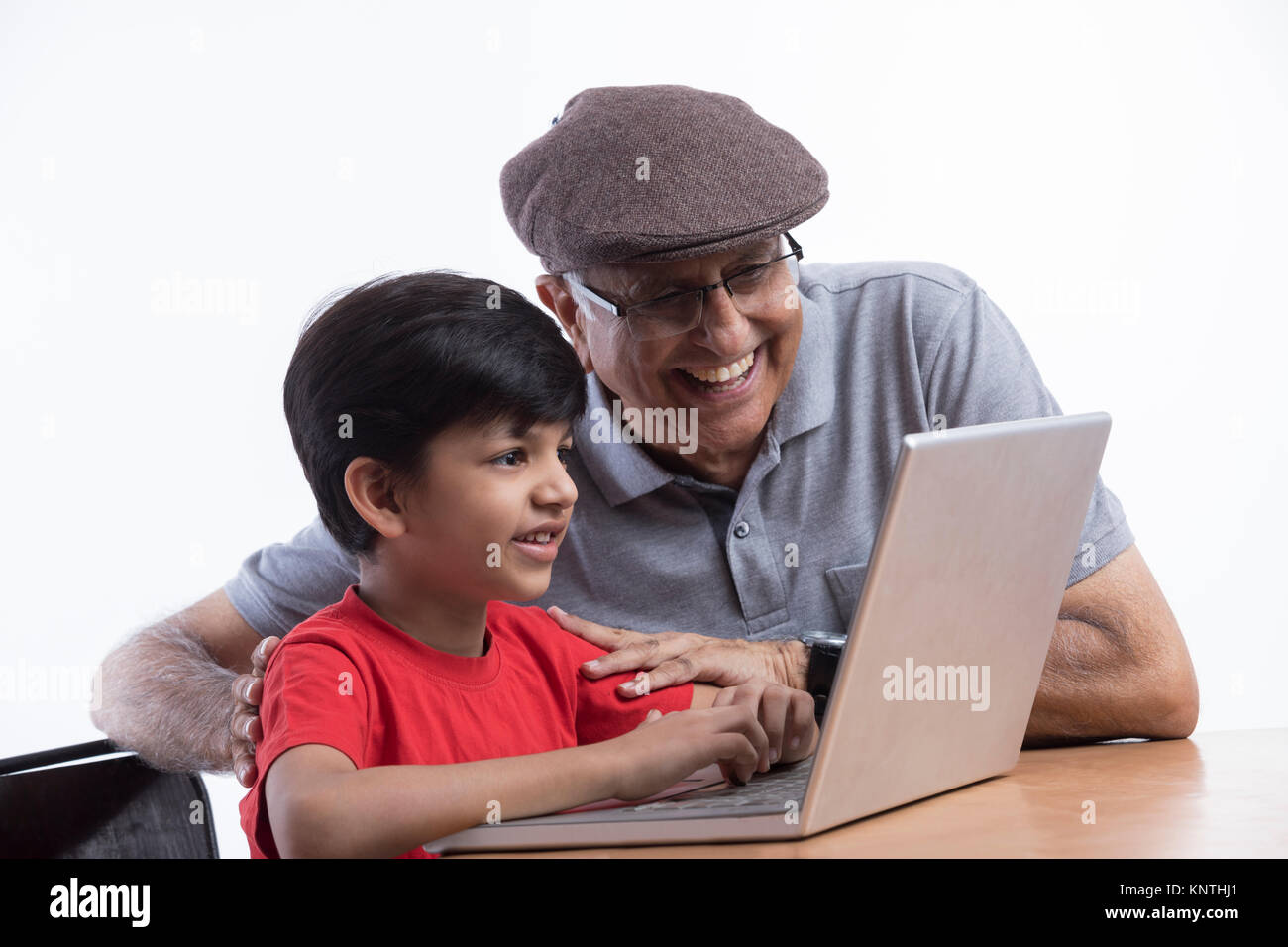 Happy grandfather and grandson using laptop Stock Photo