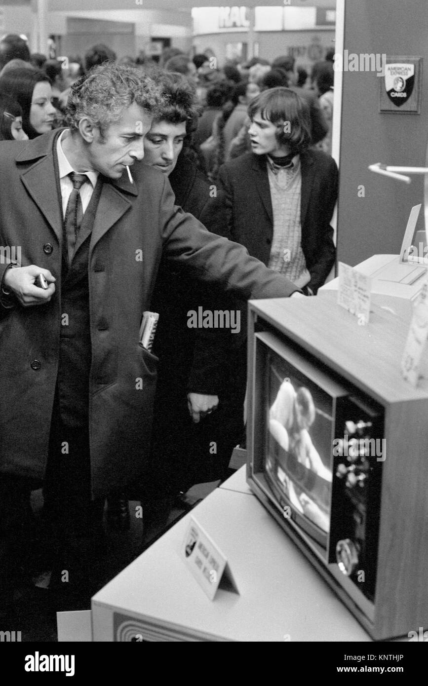 New Year January Sales 1972. Crowds people a man smoking  and looking at a a television set that price has been reduced. They are shopping for a new television TV.  1970s UK HOMER SYKES Stock Photo