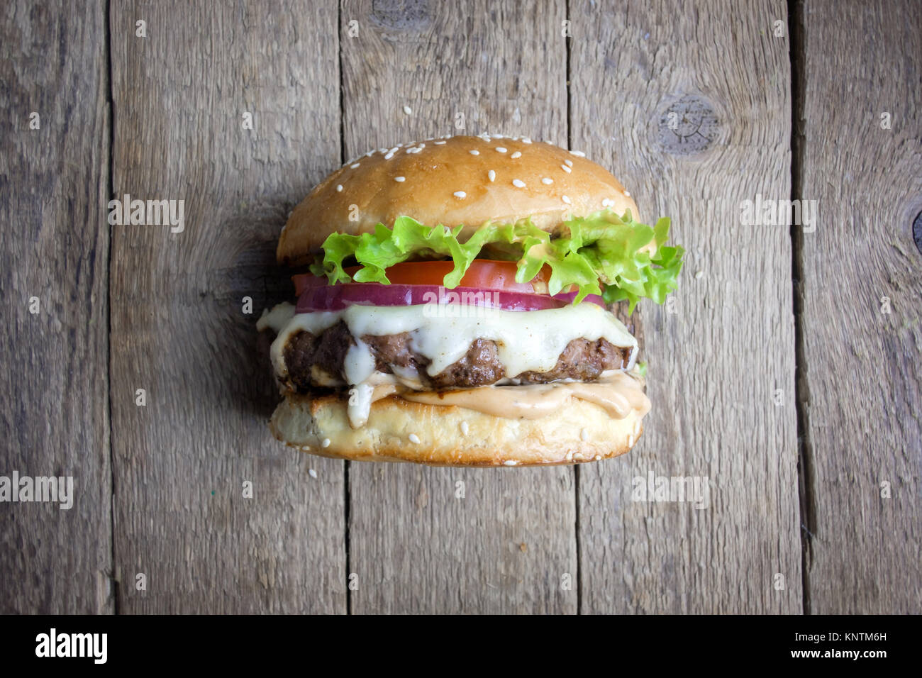 Appetizing cheeseburger on wooden table. Stock Photo