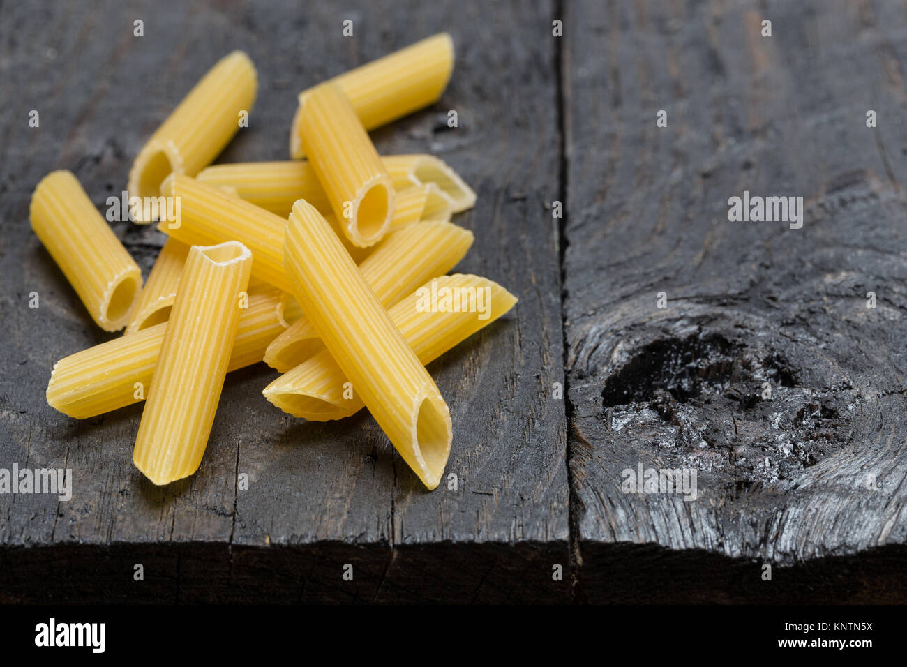 Tortiglioni noodle on dark rustic wood. Stock Photo