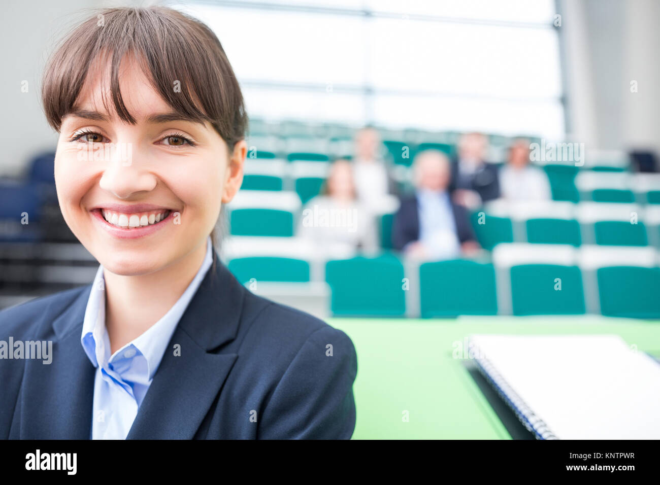 Portrait of young businesswoman smiling in lecture hall Stock Photo