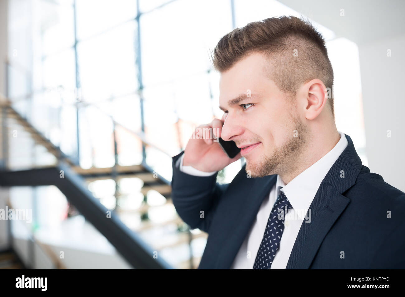 Closeup of young businessman using smartphone in office Stock Photo