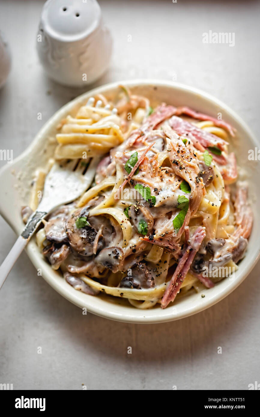 Tagliatelle ham mushroom. Pasta in cream sauce with smoked ham and