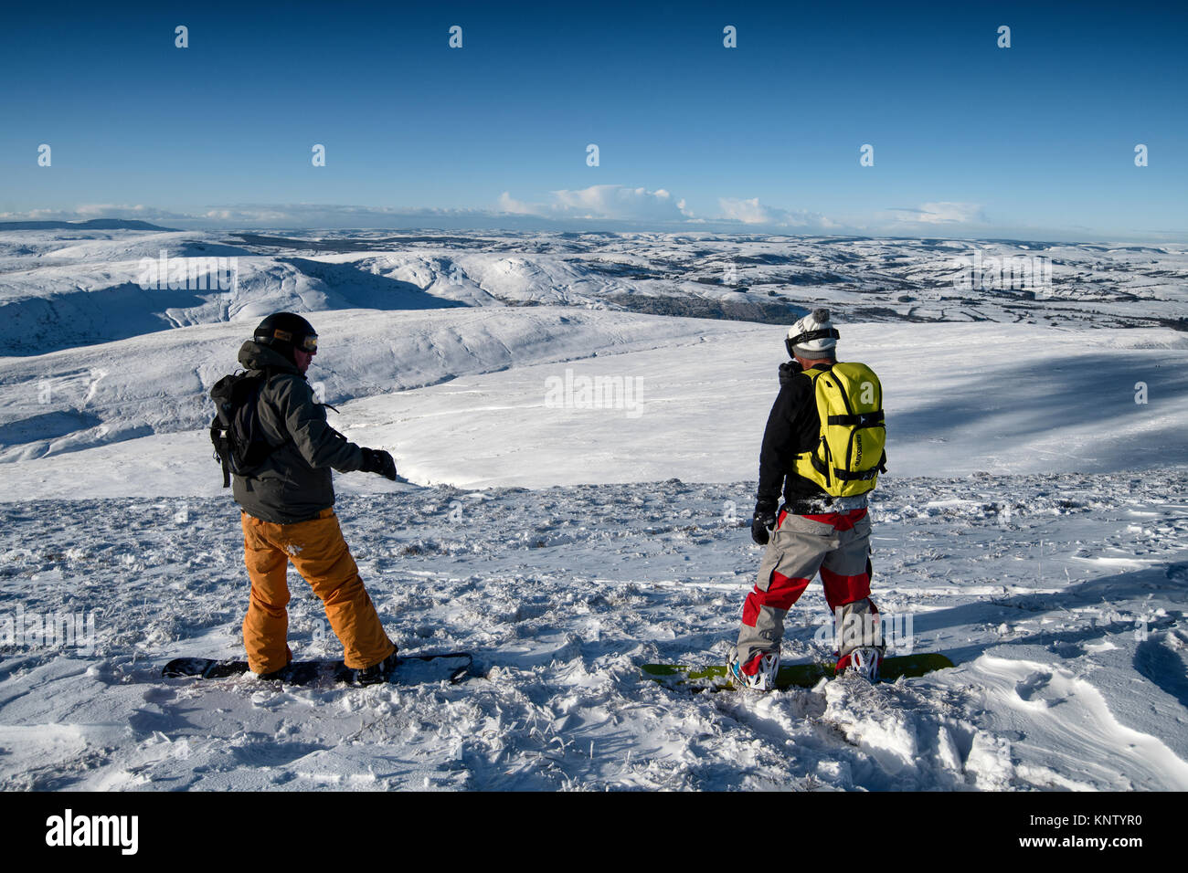 Two men on snowboards prepare to ride down the slopes of Penyfan in