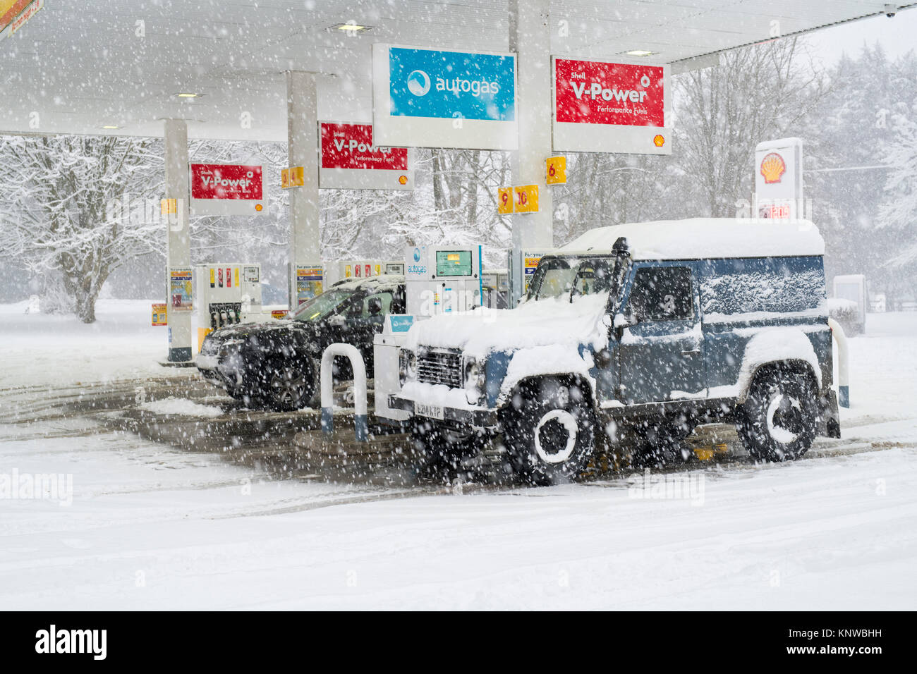 Land Rover and Dacia duster in a petrol station in the snow. Chipping norton, Oxfordshire, England Stock Photo