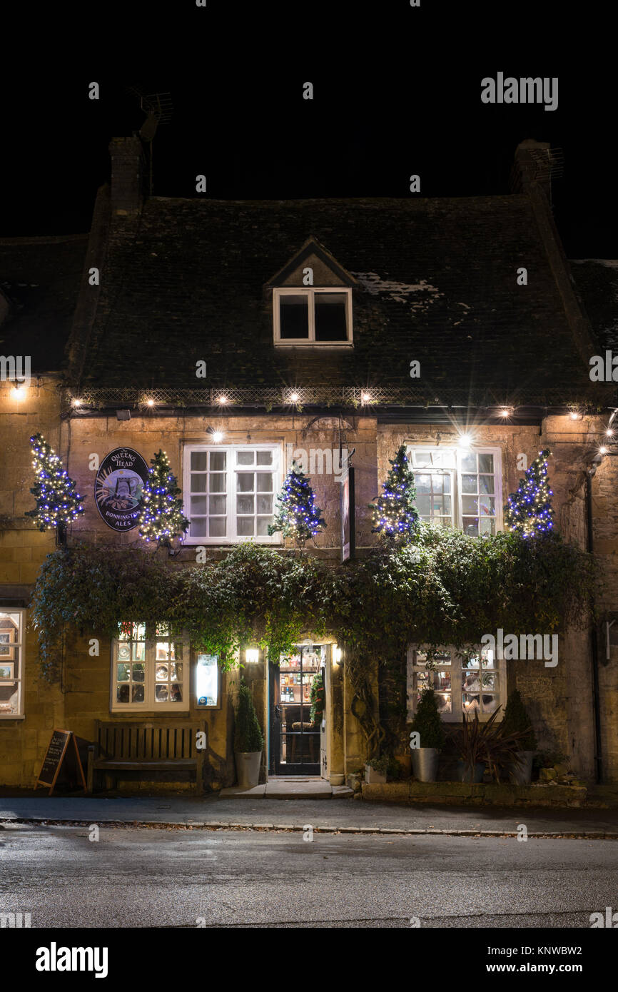 The Queens head inn with christmas trees and decorations at night. Stow