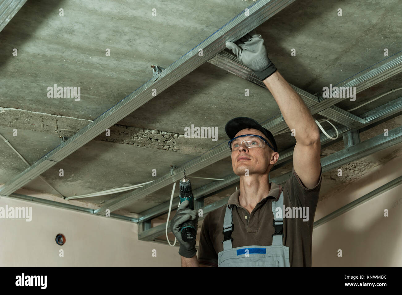 Worker Assembles Profile Metal Frame For Plasterboard Ceilings