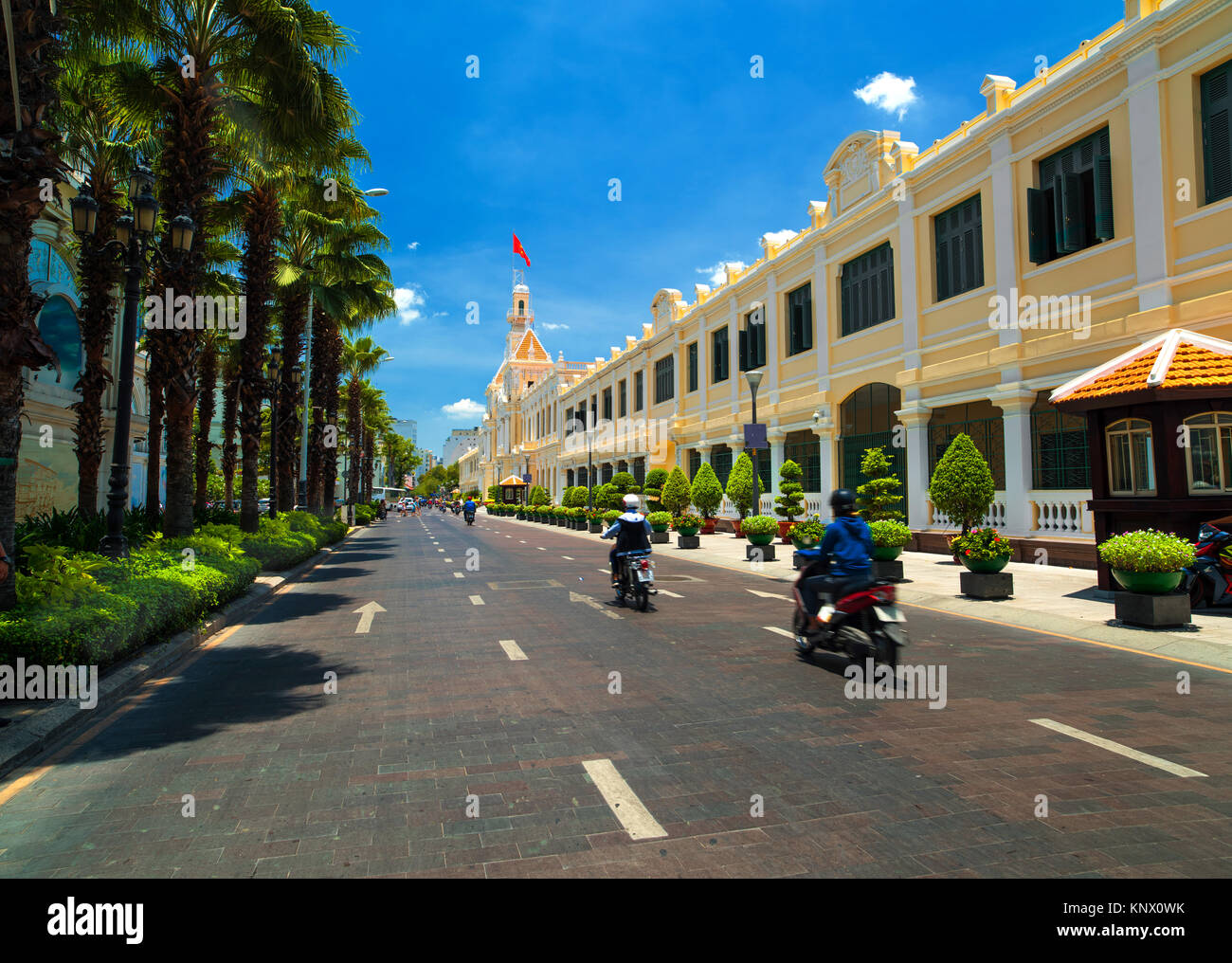 People at street on motorbikes near Saigon City Hall,  Ho Chi Minh City. Stock Photo