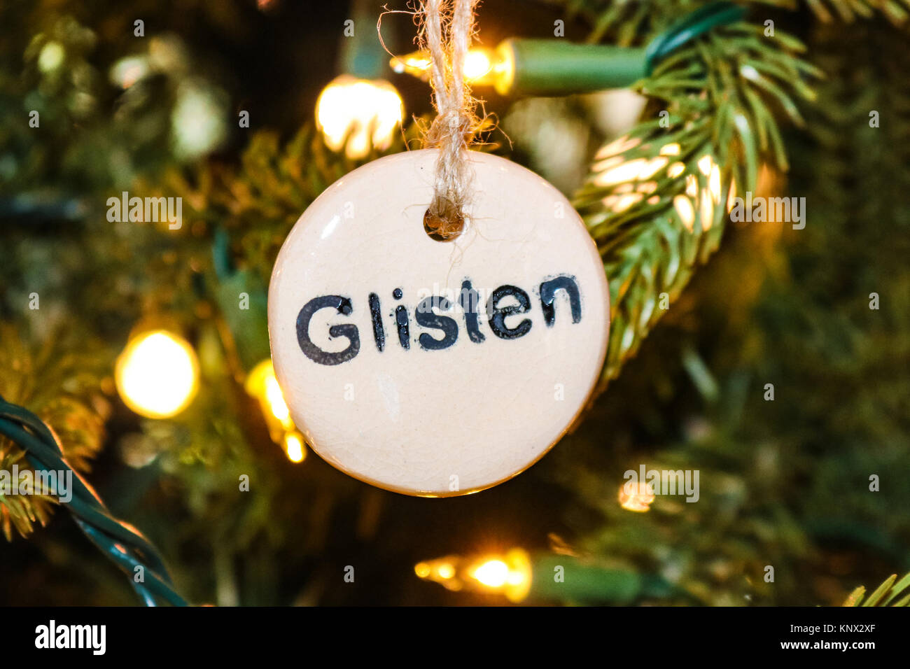 Stamped Glisten Christmas ornament on tree with strings of lights - closeup Stock Photo