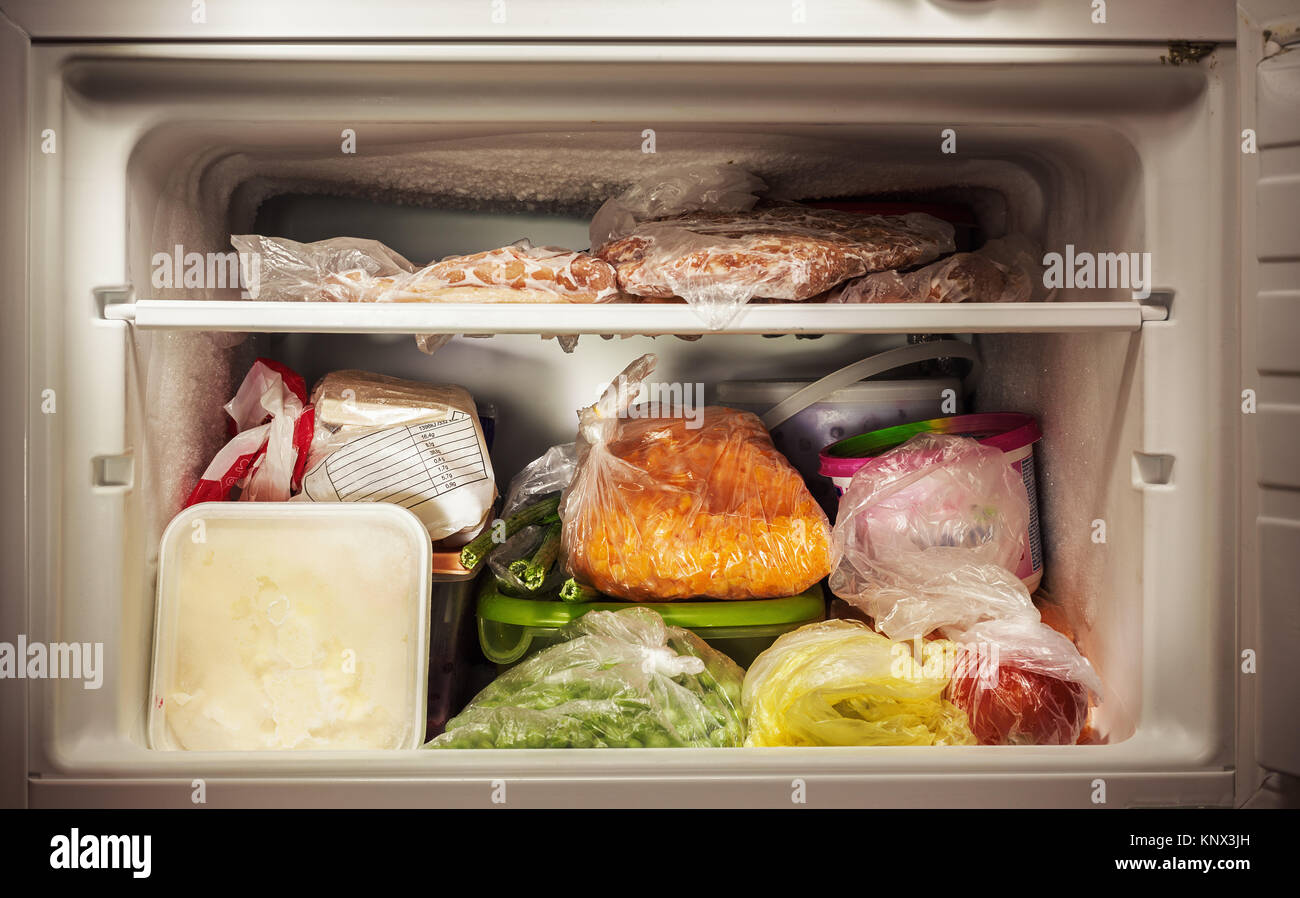 Various frozen food in freezer, illuminated details. Stock Photo