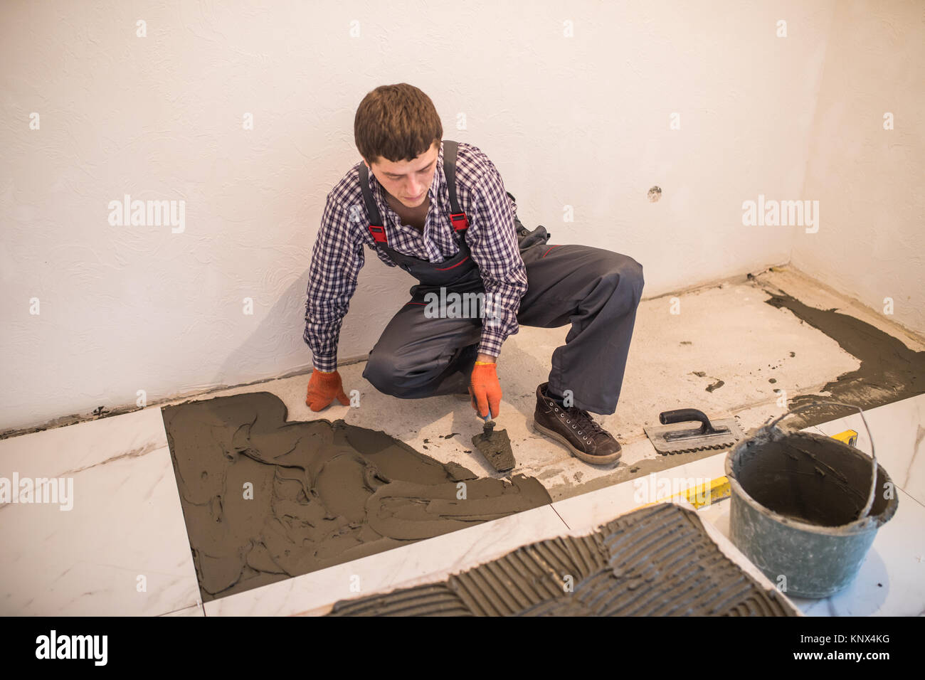 Laying Ceramic Tiles Worker Placing Ceramic Floor Tile In