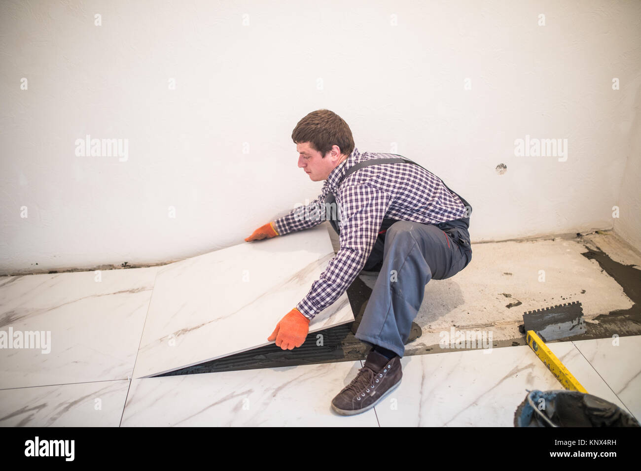 Laying Ceramic Tiles Worker Placing Ceramic Floor Tile In