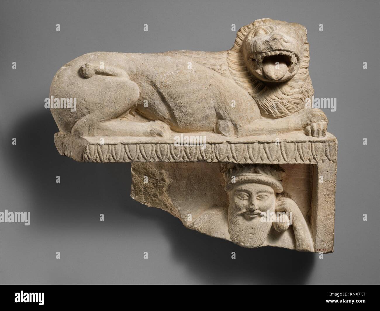 Limestone finial of a funerary stele with a recumbent lion and a ...