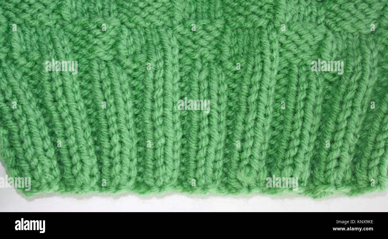 Close up of the knitted Rib Stitch.  Knit two, purl two, knit two, purl two in a pretty green color wool.  Then knitted in a Basket Weave stitch Stock Photo
