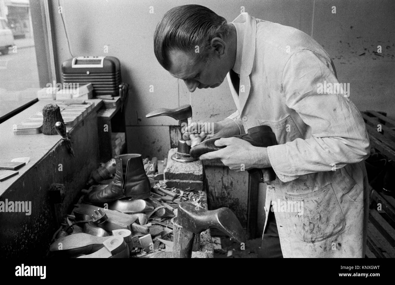 Cobbler shoe repair man 1970s repairing shoes interior of his shop. The shoe repair bench.  New Kings Road, Parsons Green, London 1972.  70s UK HOMER SYKES Stock Photo