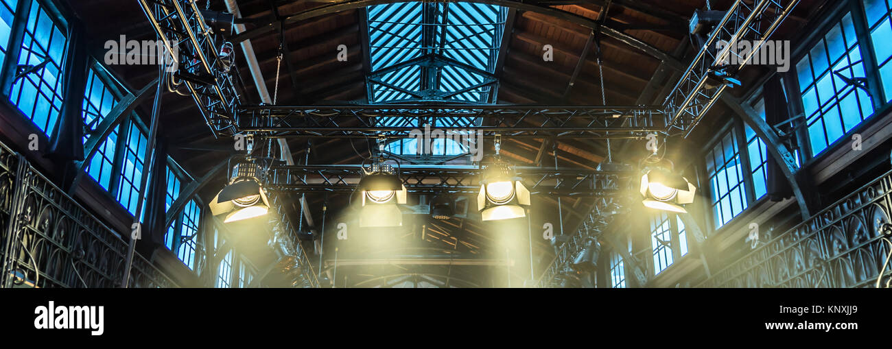 Spotlight on the ceiling of a former factory hall for lighting during a concert with rock music Stock Photo