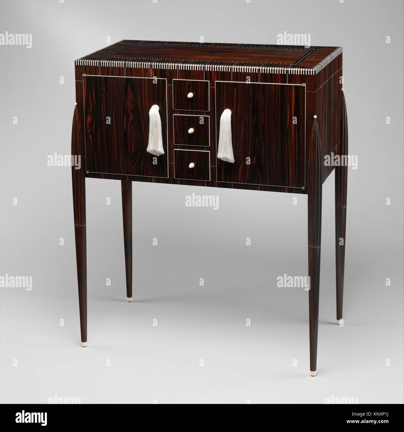 Fuseaux Cabinet. Designer: Émile-Jacques Ruhlmann (French, Paris 1879-1933 Paris); Date: ca. 1925; Medium: Macassar ebony, ivory, silk, silvered Stock Photo