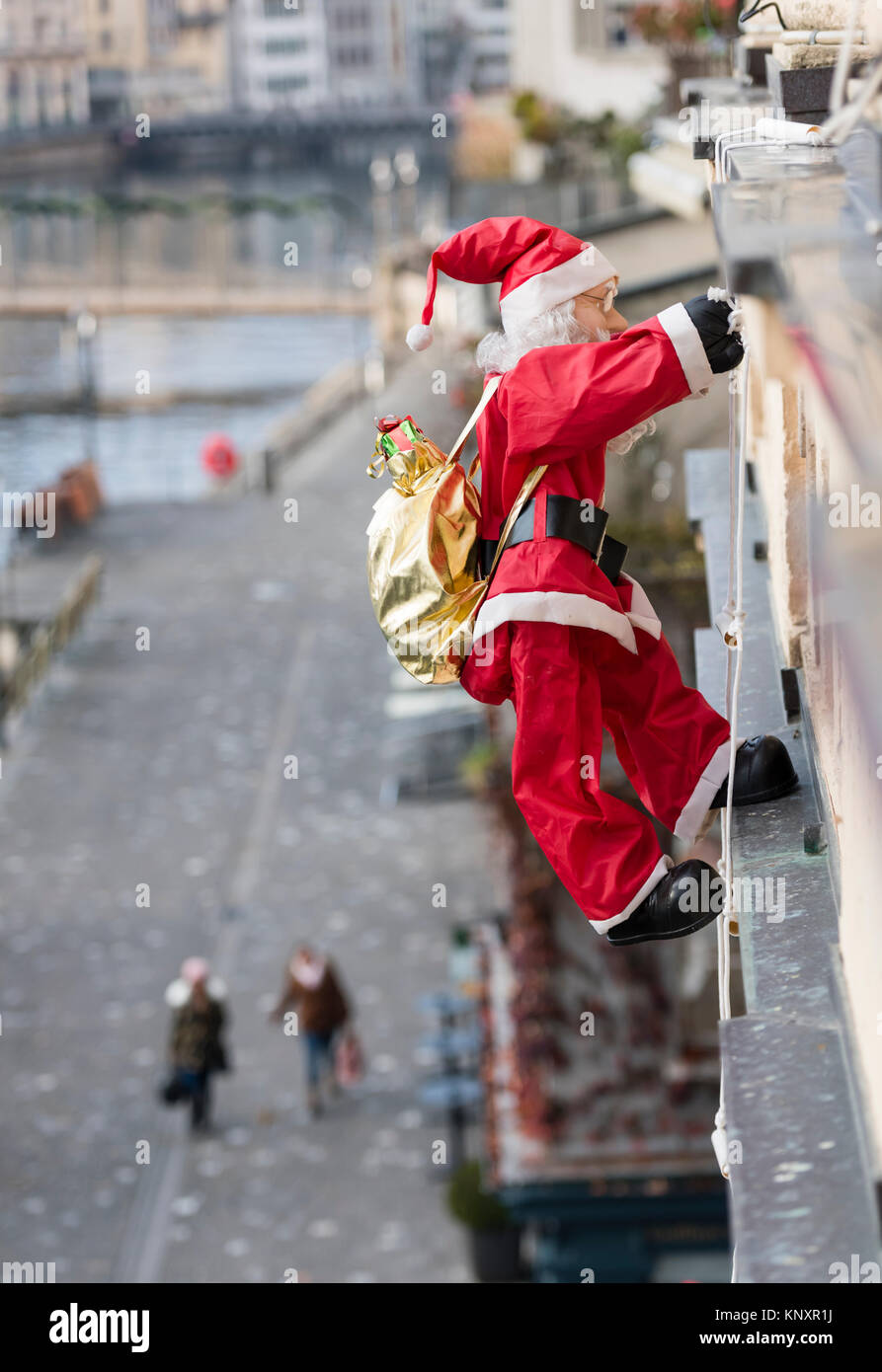 Lucerne, Switzerland - 3 Dec 2017: As Christmas decorations, a Santa Claus puppet with Christmas presents is climbing up the facade of a house at Luce Stock Photo