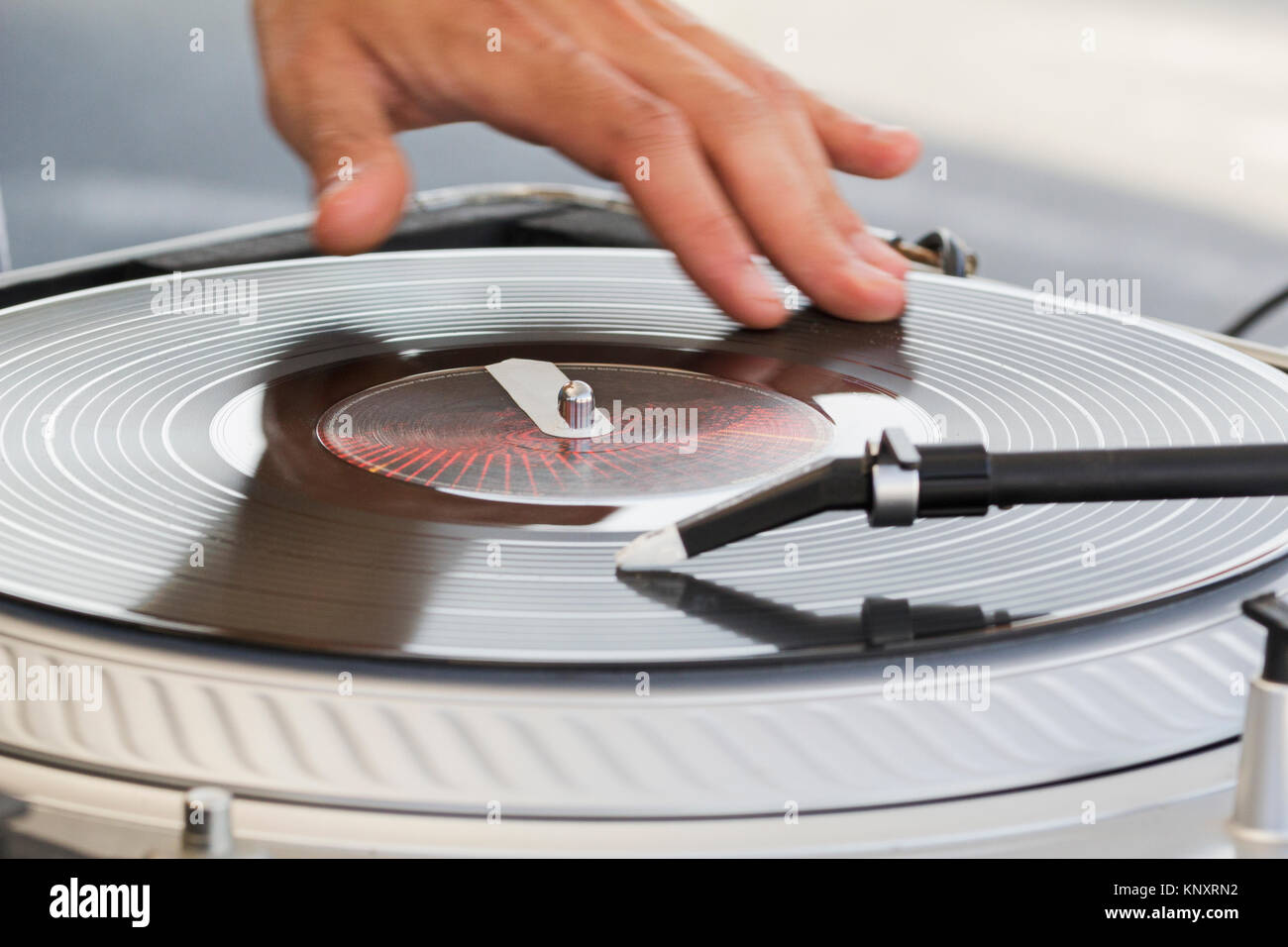The dj uses vinyl records to mix electronic music and beat rap
