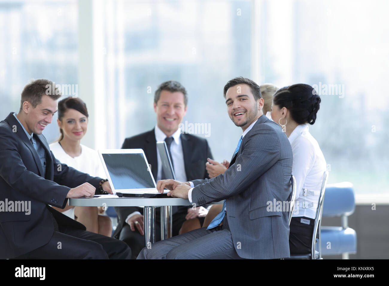 group of smiling business people sitting in a meeting room Stock Photo ...