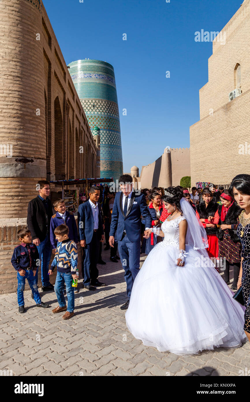 A Young Uzbek Couple Walk Through The Streets Of Khiva After Getting Married, Khiva, Uzbekistan Stock Photo