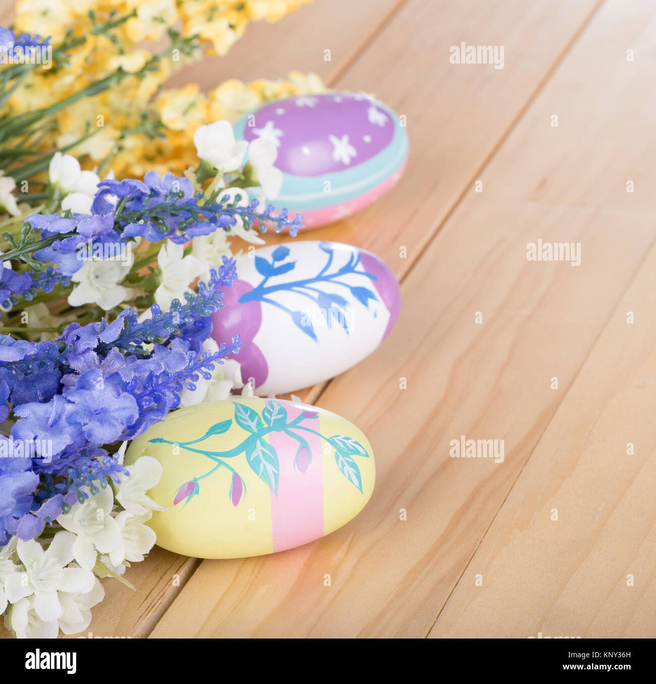 Colorful Easter eggs and flowers on a wood surface Stock Photo - Alamy