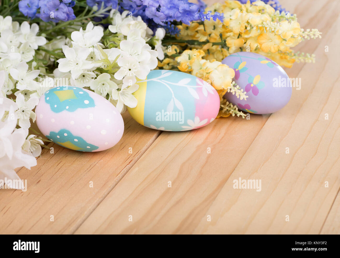 Colorful Easter eggs and flowers on a wood surface Stock Photo - Alamy