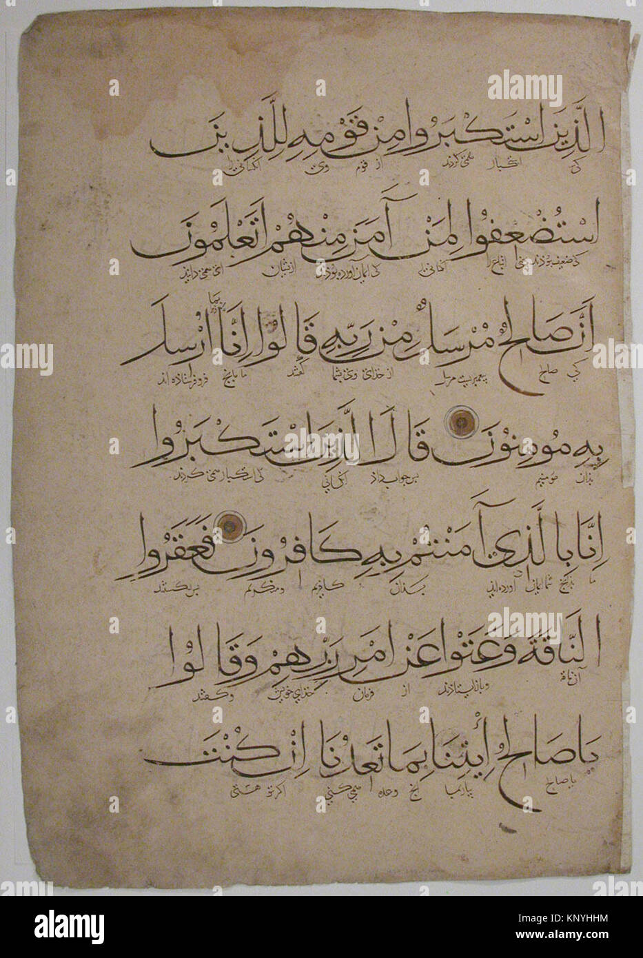 This Qur'an folio features handwritten Arabic text on paper, preserved ...